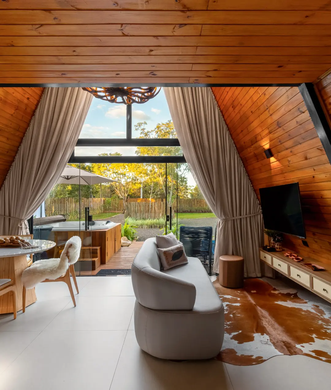 Sala da Zaruna com acabamento em madeira e vista para o SPA no jardim